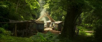 Movie still from “Yardie” (2018), directed by Idris Elba – A group of people standing in the middle of a forest; Extreme Wide shot, Low angle