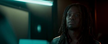 Movie still from “Yardie” (2018), directed by Idris Elba – A man with dreads is looking into the distance; Close Up shot, Low angle