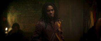 Movie still from “Yardie” (2018), directed by Idris Elba – A man with dreads standing in a dark room; Close Up shot, Low angle