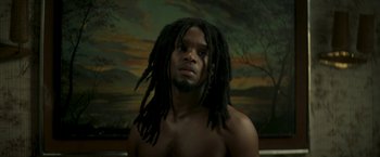 Movie still from “Yardie” (2018), directed by Idris Elba – A man with dreads is posing for a picture; Close Up shot, Low angle