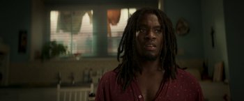 Movie still from “Yardie” (2018), directed by Idris Elba – A person with dreadlocks in a room; Close Up shot, Low angle