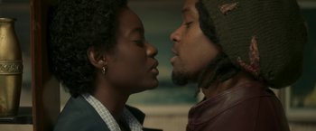 Movie still from “Yardie” (2018), directed by Idris Elba – A man and a woman are kissing in a room; Close Up shot, Low angle
