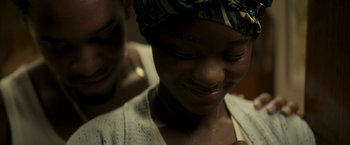 Movie still from “Yardie” (2018), directed by Idris Elba – A person wearing a head scarf; Close Up shot, Over the shoulder angle