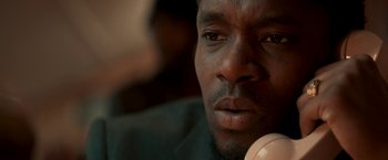 Movie still from “Yardie” (2018), directed by Idris Elba – A man's face as he looks into the distance; Extreme Close Up shot, Low angle