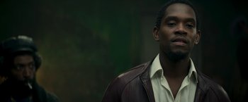 Movie still from “Yardie” (2018), directed by Idris Elba – A person wearing a leather jacket; Close Up shot, Low angle