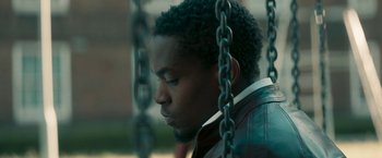 Movie still from “Yardie” (2018), directed by Idris Elba – A person sitting on a swing; Close Up shot, Low angle