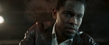 Movie still from “Yardie” (2018), directed by Idris Elba – A person wearing a leather jacket; Close Up shot, Low angle