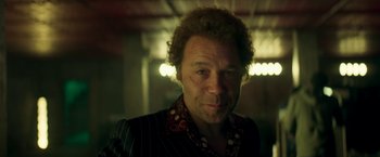 Movie still from “Yardie” (2018), directed by Idris Elba – A person with curly hair wearing a suit; Close Up shot, Low angle