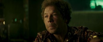 Movie still from “Yardie” (2018), directed by Idris Elba – A person wearing a floral shirt; Close Up shot, Low angle