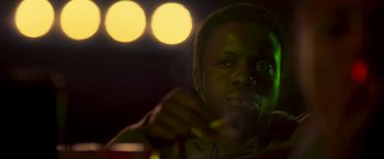 Movie still from “Yardie” (2018), directed by Idris Elba – A person holding a cup of coffee; Close Up shot, Low angle