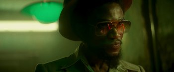Movie still from “Yardie” (2018), directed by Idris Elba – A person wearing a hat and sunglasses; Close Up shot, Low angle