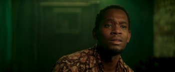 Movie still from “Yardie” (2018), directed by Idris Elba – A person wearing a brown shirt; Close Up shot, Low angle