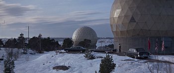 Movie still from “You Only Live Twice” (1967), directed by Lewis Gilbert – A man standing next to a car on a snowy hill; Extreme Wide shot, Low angle