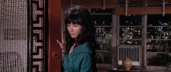Movie still from “You Only Live Twice” (1967), directed by Lewis Gilbert – A young woman in a green dress standing in front of a window; Close Up shot, Low angle