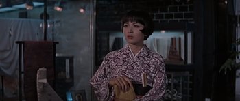 Movie still from “You Only Live Twice” (1967), directed by Lewis Gilbert – A woman in a kimono holding a piece of paper; Medium shot, Over the shoulder angle