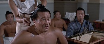 Movie still from “You Only Live Twice” (1967), directed by Lewis Gilbert – A man getting his head shaved by a barber; Close Up shot, Over the shoulder angle