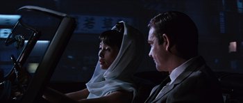 Movie still from “You Only Live Twice” (1967), directed by Lewis Gilbert – A man and a woman sitting next to each other; Close Up shot, Over the shoulder angle