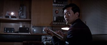 Movie still from “You Only Live Twice” (1967), directed by Lewis Gilbert – A man sitting in front of an old television; Medium shot, Low angle