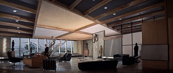 Movie still from “You Only Live Twice” (1967), directed by Lewis Gilbert – A man sitting in a chair next to a table in a room; Extreme Wide shot, High angle