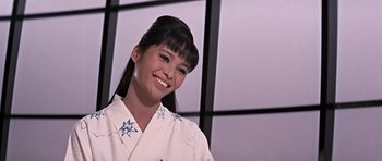 Movie still from “You Only Live Twice” (1967), directed by Lewis Gilbert – A woman in a kimono smiling for the camera; Close Up shot, Low angle