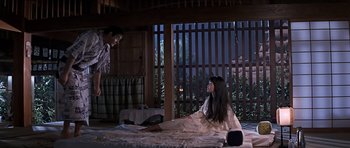 Movie still from “You Only Live Twice” (1967), directed by Lewis Gilbert – A woman sitting on the floor in front of a man; Wide shot, High angle