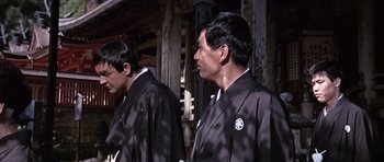 Movie still from “You Only Live Twice” (1967), directed by Lewis Gilbert – Two men in traditional japanese garb standing in front of a building; Medium shot, Low angle