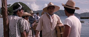 Movie still from “You Only Live Twice” (1967), directed by Lewis Gilbert – A group of people standing next to a body of water; Medium shot, Low angle
