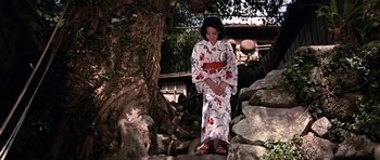 Movie still from “You Only Live Twice” (1967), directed by Lewis Gilbert – A woman in a kimono standing next to a tree; Wide shot, Low angle