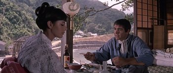 Movie still from “You Only Live Twice” (1967), directed by Lewis Gilbert – A man and a woman sitting at a table; Medium shot, Over the shoulder angle