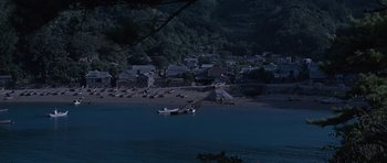 Movie still from “You Only Live Twice” (1967), directed by Lewis Gilbert – A boat is in the middle of the water near the shore; Extreme Wide shot, High angle