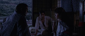 Movie still from “You Only Live Twice” (1967), directed by Lewis Gilbert – A man and two women sitting in a room; Medium shot, Over the shoulder angle