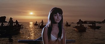 Movie still from “You Only Live Twice” (1967), directed by Lewis Gilbert – A woman standing in front of a body of water; Medium shot, Low angle