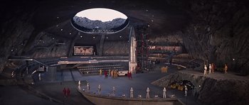 Movie still from “You Only Live Twice” (1967), directed by Lewis Gilbert – A group of people standing in a room with a building; Extreme Wide shot, High angle