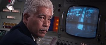 Movie still from “You Only Live Twice” (1967), directed by Lewis Gilbert – An older man in a suit looking at the camera; Close Up shot, Low angle