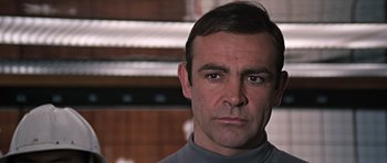 Movie still from “You Only Live Twice” (1967), directed by Lewis Gilbert – A person wearing a gray shirt; Close Up shot, Low angle