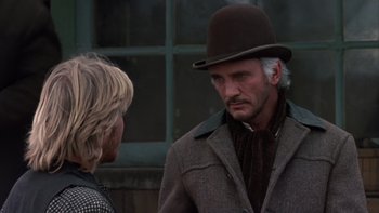 Movie still from “Young Guns” (1988), directed by Christopher Cain – A man wearing a hat talking to a woman; Close Up shot, Over the shoulder angle