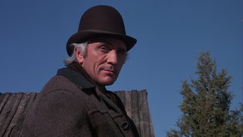 Movie still from “Young Guns” (1988), directed by Christopher Cain – An older man wearing a hat and a coat; Close Up shot, Low angle