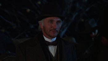 Movie still from “Young Guns” (1988), directed by Christopher Cain – A man in a top hat and a suit and tie; Close Up shot, Low angle