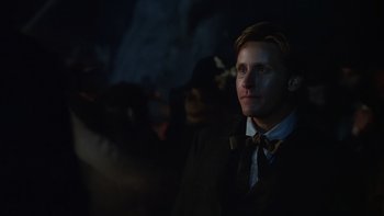 Movie still from “Young Guns” (1988), directed by Christopher Cain – A man in a suit and bow tie looking up at the sky; Close Up shot, Over the shoulder angle