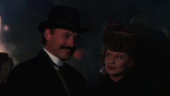 Movie still from “Young Guns” (1988), directed by Christopher Cain – A man and a woman in a suit and hat; Close Up shot, Low angle
