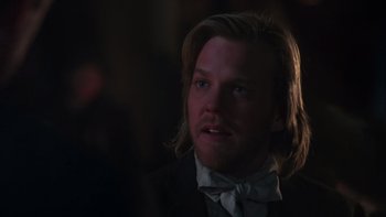 Movie still from “Young Guns” (1988), directed by Christopher Cain – A person wearing a suit and bow tie; Close Up shot, Over the shoulder angle