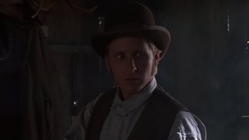 Movie still from “Young Guns” (1988), directed by Christopher Cain – A man wearing a brown hat and a vest; Close Up shot, Low angle