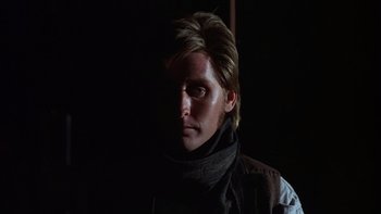 Movie still from “Young Guns” (1988), directed by Christopher Cain – A man with long blonde hair wearing a black scarf; Close Up shot, Low angle