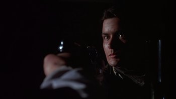 Movie still from “Young Guns” (1988), directed by Christopher Cain – A man holding a gun in a dark room; Close Up shot, Low angle