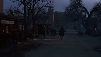 Movie still from “Young Guns” (1988), directed by Christopher Cain – A man riding a horse in the middle of the night; Extreme Wide shot, Low angle