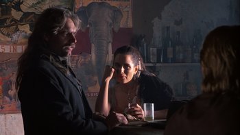Movie still from “Young Guns” (1988), directed by Christopher Cain – A man and a woman sitting at a table; Medium shot, Over the shoulder angle