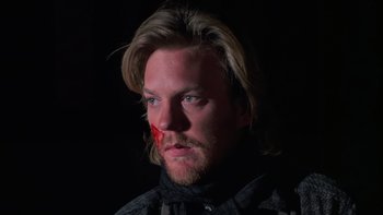 Movie still from “Young Guns” (1988), directed by Christopher Cain – A person with a blood spot on his face; Close Up shot, Low angle