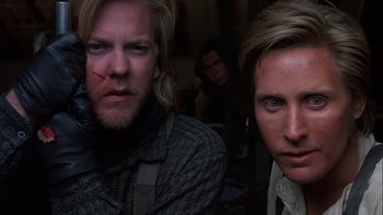 Movie still from “Young Guns” (1988), directed by Christopher Cain – A man with long blonde hair and a man with blonde hair and blue eyes; Close Up shot, Low angle