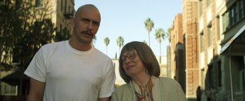 Movie still from “Zeroville” (2019), directed by James Franco – A man standing next to an older woman in front of palm trees; Close Up shot, Low angle