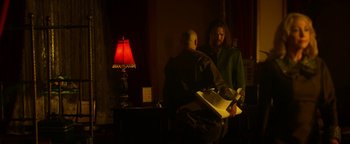 Movie still from “Zeroville” (2019), directed by James Franco – Two people standing in front of a table with a red lamp; Medium shot, Over the shoulder angle